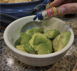 Making guacamole with Travel Sauce salt, pepper and hot sauce